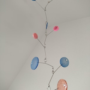 Delicate circles, handcrafted mobile sculpture made of epoxy resin and stainless steel, inspired by organic plant forms. TaJo Design blue-red