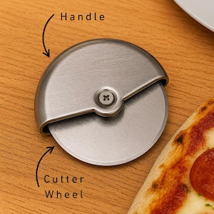 May include: A stainless steel pizza cutter with a circular blade and a curved handle. The cutter wheel is visible, along with a portion of a pizza with pepperoni.