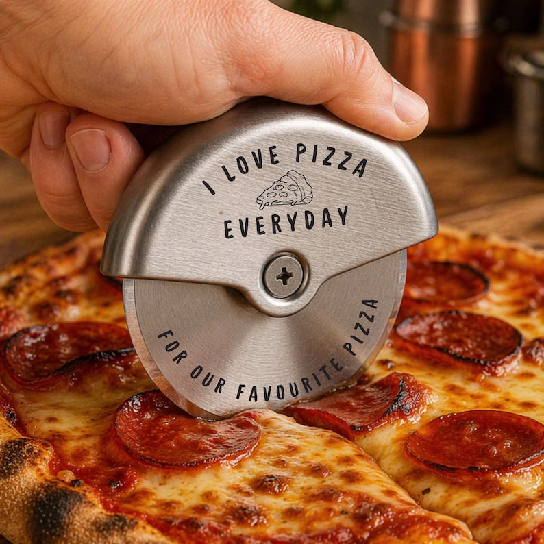 May include: A stainless steel pizza cutter with the text "I LOVE PIZZA EVERYDAY" and "FOR OUR FAVOURITE PIZZA" is cutting a pepperoni pizza. The pizza has melted cheese and pepperoni slices.