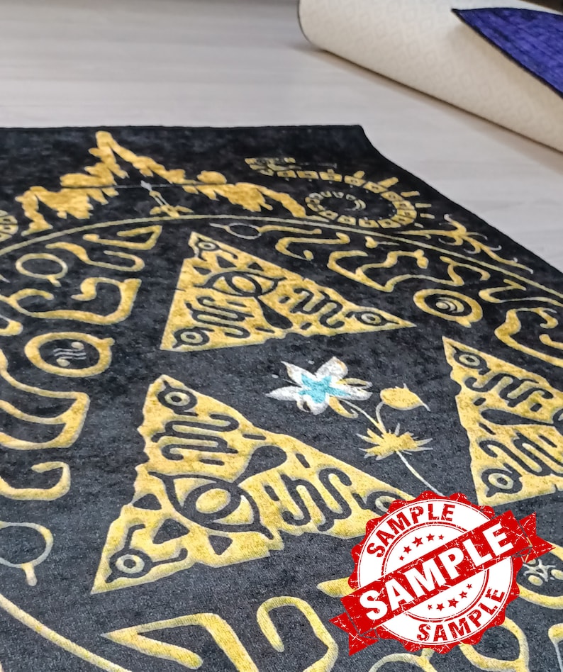 May include: A black and gold rug with a triangular pattern and a flower design. The rug has a "SAMPLE" stamp on it.