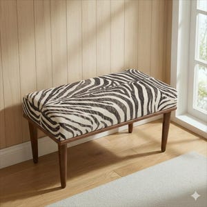 May include: A rectangular bench with a zebra print seat cushion. The cushion is black and white, and the frame and legs are a dark brown. The bench is placed on a hardwood floor.