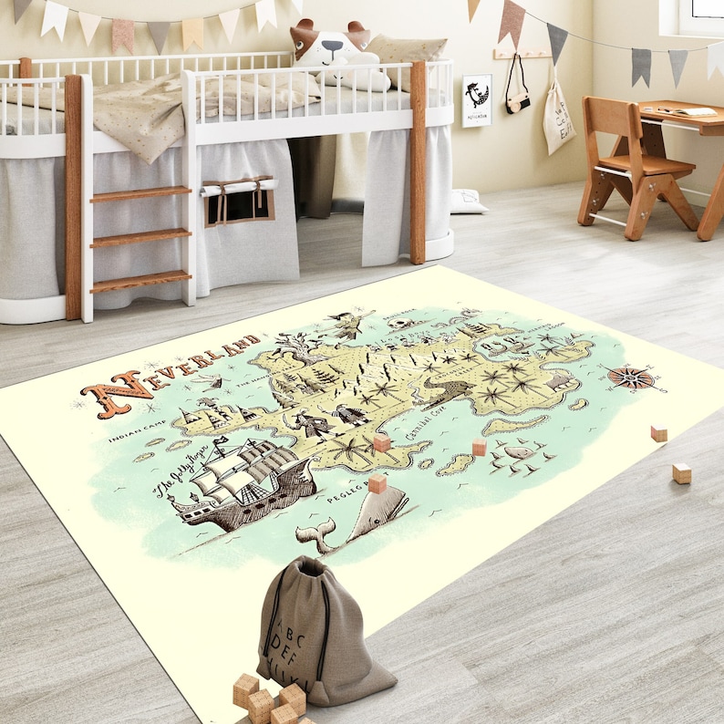 Op de afbeelding: Een beige en blauwe vloerkleed met een kaart van Neverland. De kaart toont een piratenschip, een walvis en verschillende bezienswaardigheden. Het vloerkleed is perfect voor een kinderkamer of speelkamer.