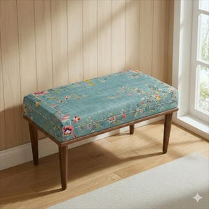 May include: A rectangular bench with a teal floral patterned cushion and dark brown wooden legs. The cushion features a detailed design of colourful flowers and foliage. The bench is a decorative furniture piece.