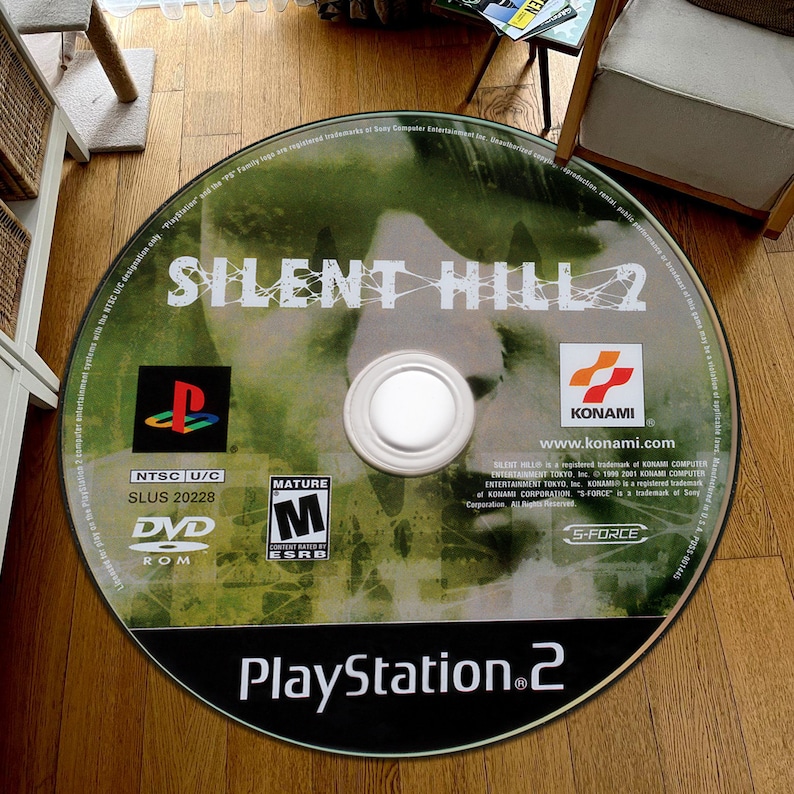 May include: A green and black PlayStation 2 game disc for Silent Hill 2. The disc has a mature rating and is labeled NTSC U/C. The disc is labeled SLUS 20228.
