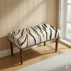 May include: A rectangular bench with a faux tiger stripe pattern in black and cream. The bench has a wooden frame and legs. The bench is placed in front of a light wood-paneled wall and a window.