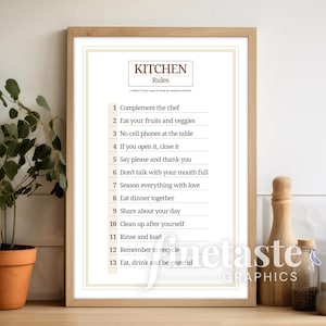 Op de afbeelding: Een printbare poster met keukenregels met een bruine houten lijst. De poster heeft een witte achtergrond met bruine tekst die "Keukenregels" luidt. De regels zijn in numerieke volgorde opgesomd, met elke regel op een aparte regel. De regels omvatten: "Complimenteer de kok", "Eet je fruit en groenten", "Geen mobiele telefoons aan tafel", "Als je het opent, sluit het dan", "Zeg alstublieft en dank je", "Praat niet met je mond vol", "Kruid alles met liefde", "Eet samen diner", "Deel je dag", "Ruim op na jezelf", "Spoel en laad", "Denk eraan om te recyclen", en "Eet, drink en wees dankbaar".