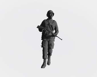 May include: A black and gray military figurine holding a rifle. The figurine is wearing a helmet and camouflage clothing.
