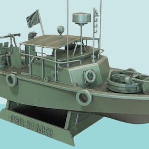 Puede incluir: Un modelo verde de una lancha patrullera PBR 31 MK2 con una ametralladora montada en la cubierta. La lancha tiene una pequeña cabina y una antena de radar en el techo.