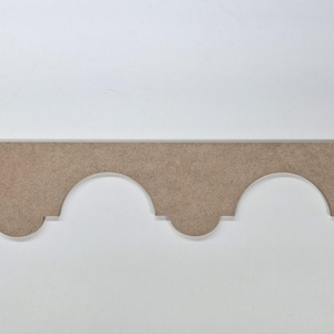 May include: A brown wooden trim with a scalloped edge. The trim is about 1 inch wide and has a subtle wood grain texture.