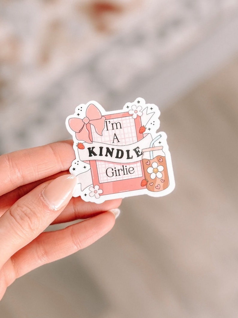 May include: A pink and white sticker with a pink and white bow, a pink book with a white grid pattern, and the text "I'm a Kindle Girlie".