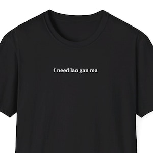 Puede incluir: Camiseta negra con el texto "I need lao gan ma" impreso en blanco en la parte delantera.