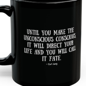 May include: Black ceramic coffee mug with a white quote by Carl Jung: "Until you make the unconscious conscious, it will direct your life and you will call it fate."