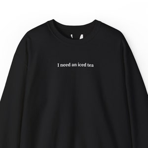 May include: Black sweatshirt with the text "I need an iced tea" printed in white on the front.