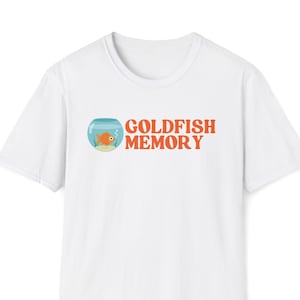 Op de afbeelding: Wit T-shirt met een cartoon-goudvis in een kom en de tekst "Goldfish Memory" in oranje.