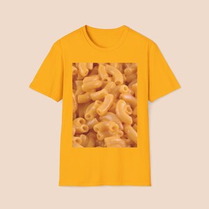 Può includere: Una maglietta gialla con un'immagine ravvicinata di maccheroni al formaggio.