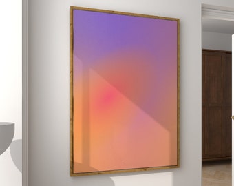 May include: An abstract artwork in a wooden frame, featuring a gradient of purple, orange, and pink hues, is displayed on a white wall. The room includes a modern lamp, a brown stool, and a wooden floor.