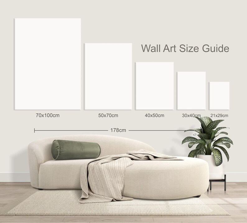May include: A wall art size guide displays five blank rectangular canvases with dimensions in centimeters. A beige sofa with a green bolster pillow and a blanket is in front of the canvases. The text "Wall Art Size Guide" is above the canvases.