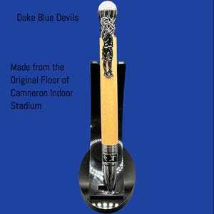 May include: A wooden pen with a silver basketball player and net design. The pen is made from the original floor of Cameron Indoor Stadium. Duke Blue Devils.