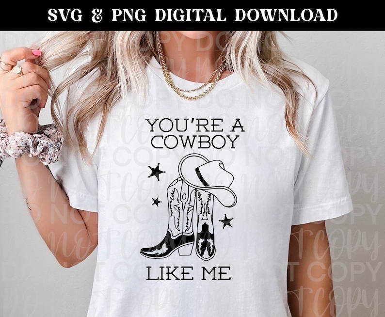 May include: White t-shirt with black text that reads "You're a Cowboy Like Me". The text is accompanied by a graphic of a cowboy hat and two cowboy boots.