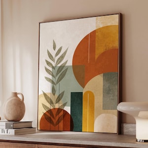 May include: Abstract art print featuring geometric shapes and botanical elements in a warm color palette. The artwork includes a large orange circle, green and yellow rectangles, and a brown frame. The print is displayed on a wooden cabinet.