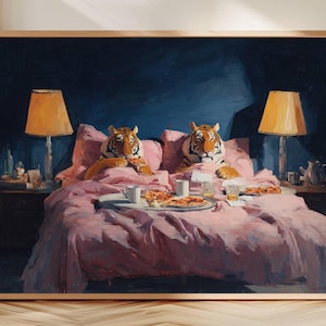 Puede incluir: Impresión artística enmarcada que representa a dos tigres en la cama con ropa de cama rosa, disfrutando de pizza y bebidas. La escena está iluminada por lámparas de noche con pantallas naranjas, sobre un fondo azul oscuro.