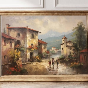 Pu&ograve; includere: Un dipinto ad olio incorniciato che rappresenta una pittoresca scena di un villaggio italiano. Il dipinto presenta una strada acciottolata fiancheggiata da edifici pittoreschi, vegetazione lussureggiante e un gruppo di persone che camminano lungo la strada. Lo sfondo include colline ondulate e un cielo azzurro.