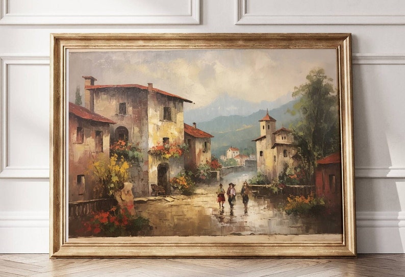 Pu&ograve; includere: Un dipinto ad olio incorniciato che rappresenta una pittoresca scena di un villaggio italiano. Il dipinto presenta una strada acciottolata fiancheggiata da edifici pittoreschi, vegetazione lussureggiante e un gruppo di persone che camminano lungo la strada. Lo sfondo include colline ondulate e un cielo azzurro.