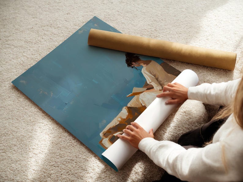 May include: An abstract art print with a blue background and a figure in white clothing. A rolled-up white canvas and a brown cardboard tube are next to the artwork. The image is on a light-colored carpet.