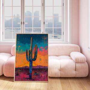 May include: A framed abstract painting of a large, blue cactus in a desert landscape with a colorful sunset in the background.
