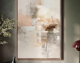 May include: Abstract art print in a wooden frame. The artwork features a blend of neutral colors, including beige, gray, and brown, with textured brushstrokes. The painting is displayed above a wooden cabinet, with a decorative bird and books.