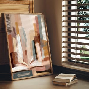 May include: Abstract art print in a wooden frame. The artwork features a colorful composition of vertical brushstrokes in shades of brown, beige, and blue, with an open book at the bottom. The print is leaning against a wooden cabinet.