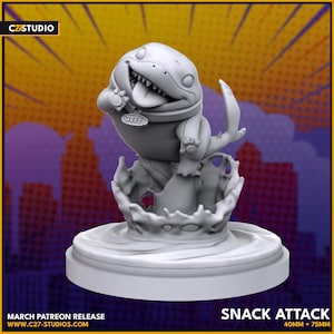Może przedstawiać: Szara figurka 3D wydrukowana z postacią kreskówkową z szerokim uśmiechem, noszącą obrożę z napisem "JEFF". Postać stoi na podstawie z efektem wodnym. Na podstawie nadrukowano tekst "SNACK ATTACK" wraz z wymiarami "40MM + 75MM".