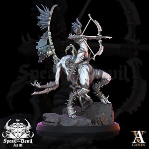 May include: A white painted miniature figurine of a demon with a female figure riding on its back. The demon has horns, claws, and a tail. The female figure is holding a bow and arrow. The miniature is on a black base with a gray rock texture.