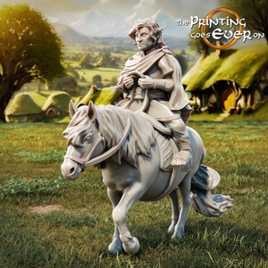 Op de afbeelding: Een wit miniatuurbeeldje van een persoon die op een paard rijdt. De persoon draagt een lange, vloeiende robe en heeft een serieuze uitdrukking op zijn gezicht. Het paard staat op een grasveld met op de achtergrond glooiende heuvels en een klein dorp.