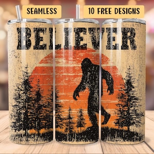 May include: A stainless steel tumbler with a Bigfoot design. The tumbler features a silhouette of Bigfoot walking in front of an orange sunset, with the word "BELIEVER" in bold letters. The design includes pine trees and the words "SEAMLESS" and "10 FREE DESIGNS".