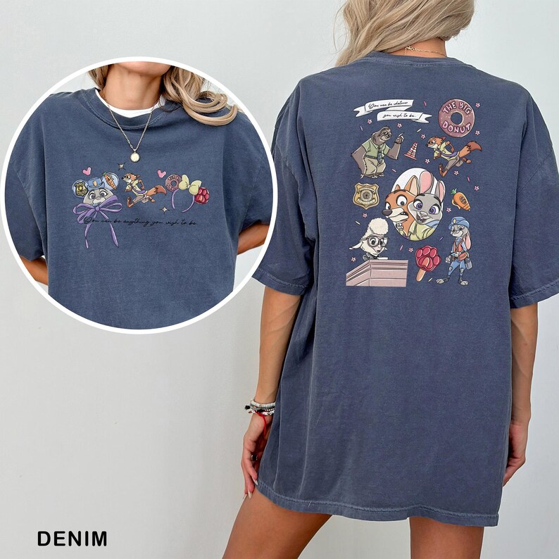 May include: Denim blue t-shirt with a cartoon graphic on the front and back. The front graphic includes a bow and character ears. The back graphic features characters and the text "The Big Donut".