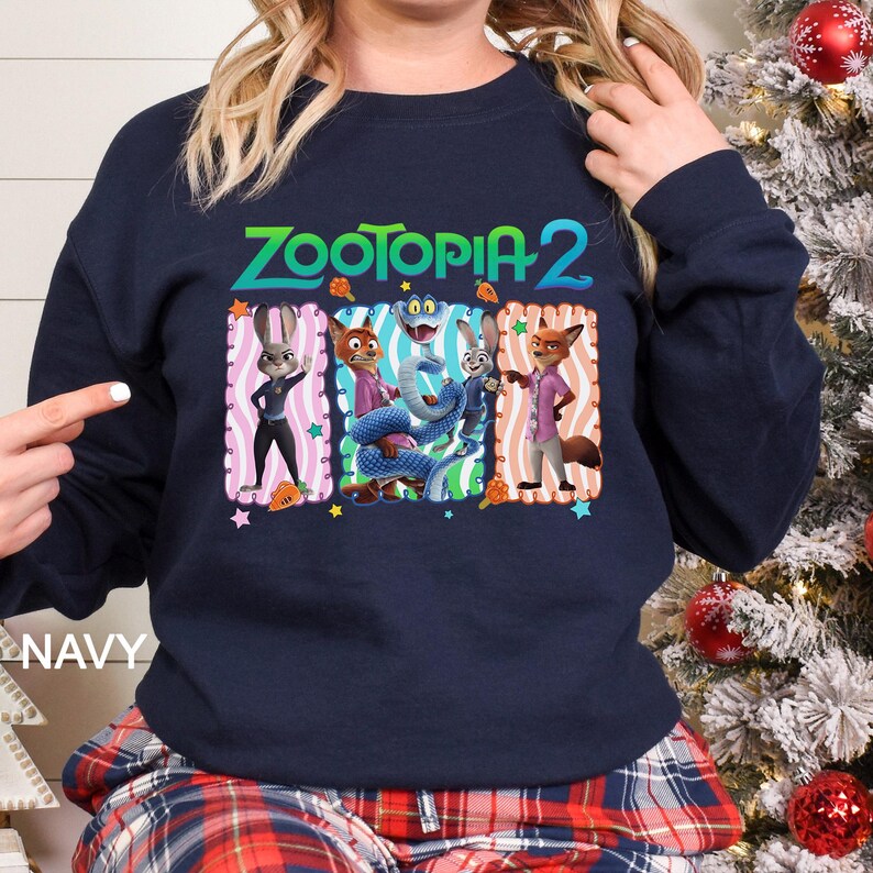 May include: Navy blue sweatshirt featuring the text "ZOOTOPIA 2" above a colorful graphic of characters from the animated movie. The graphic includes Judy Hopps, Nick Wilde, and other characters. The word "NAVY" is printed on the bottom left.