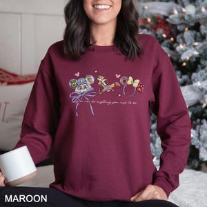May include: Maroon sweatshirt featuring a cartoon design with the text "You can be anything you wish to be." The graphic includes a mouse in a police uniform, a fox, and mouse ears. The word "MAROON" is printed at the bottom of the image.