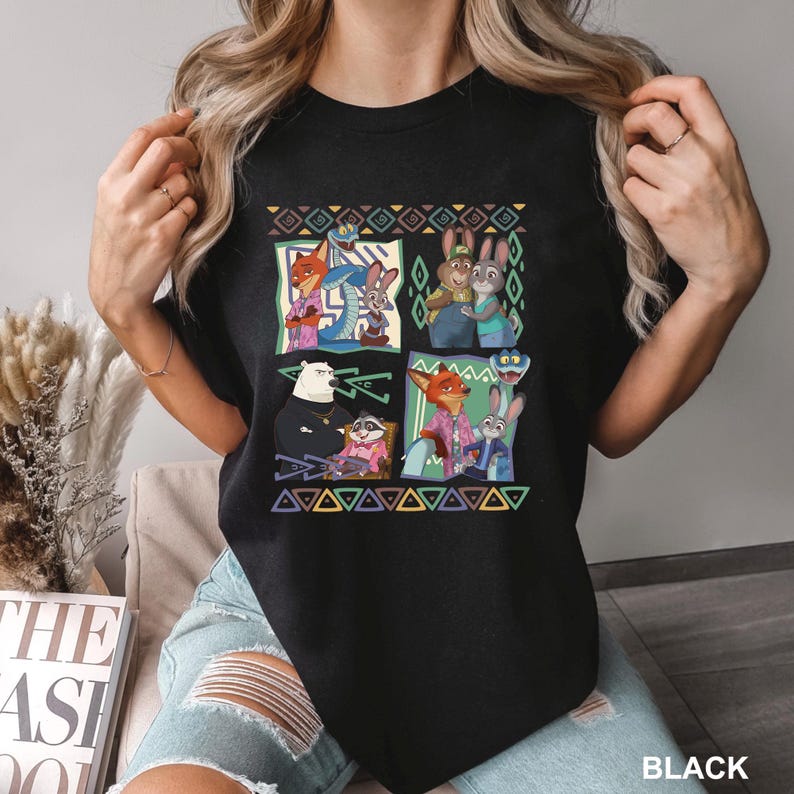 K&ouml;nnte beinhalten: Schwarzes T-Shirt mit einem farbenfrohen Grafikdesign mit Charakteren aus dem Animationsfilm Zootopia. Das Design enth&auml;lt Bilder von Nick Wilde, Judy Hopps und anderen Charakteren. Das Wort "BLACK" ist unten rechts aufgedruckt.