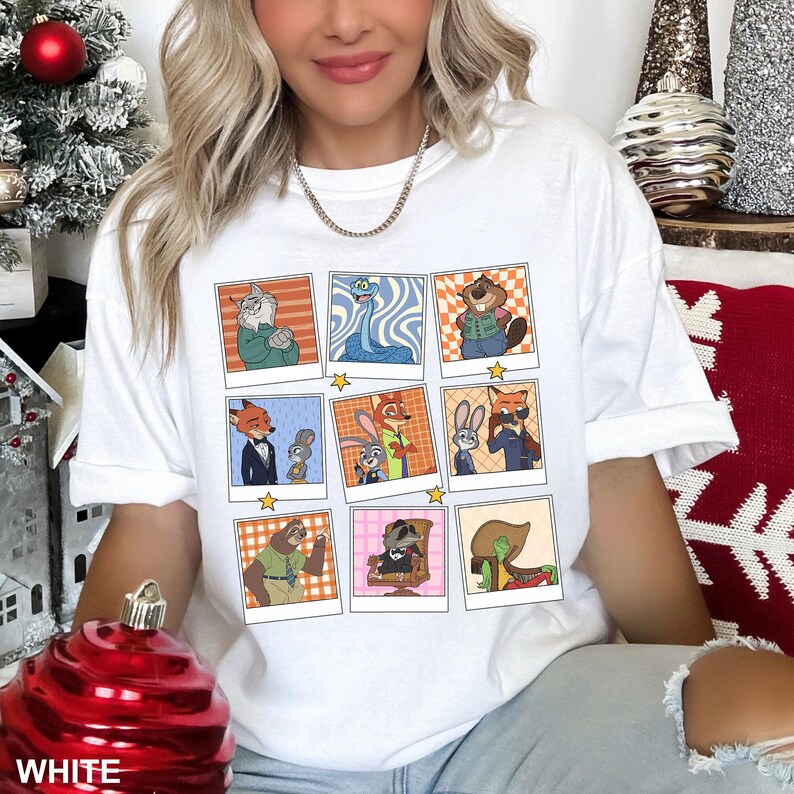 May include: White t-shirt featuring a grid of cartoon character portraits in polaroid-style frames. Each frame showcases a different character with various backgrounds. The word "WHITE" is visible at the bottom left.