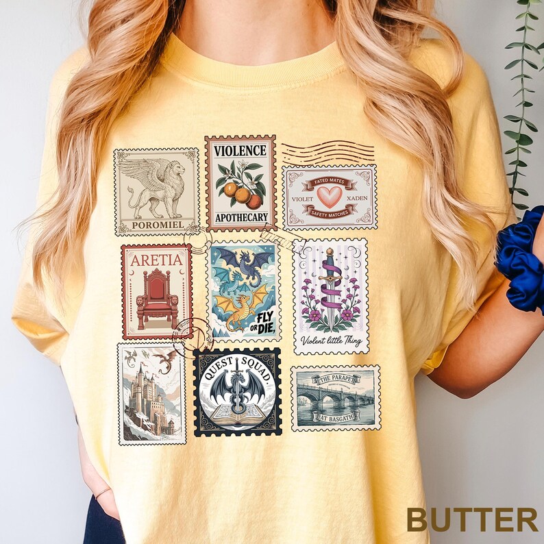 May include: Yellow t-shirt with a collection of postage stamp designs. The stamps feature illustrations of a griffin, oranges, a heart, a throne, a dragon, a sword, a castle, and a bridge. The word "BUTTER" is printed at the bottom.