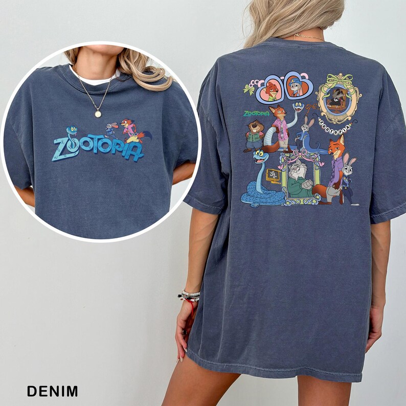 以下が含まれることがあります： 前面にターコイズ色の「Zootopia」の文字が入ったデニムブルーのTシャツ。背面にはアニメ映画「Zootopia」のキャラクターのカラフルなグラフィックが描かれています。「DENIM」の文字が下にあります。