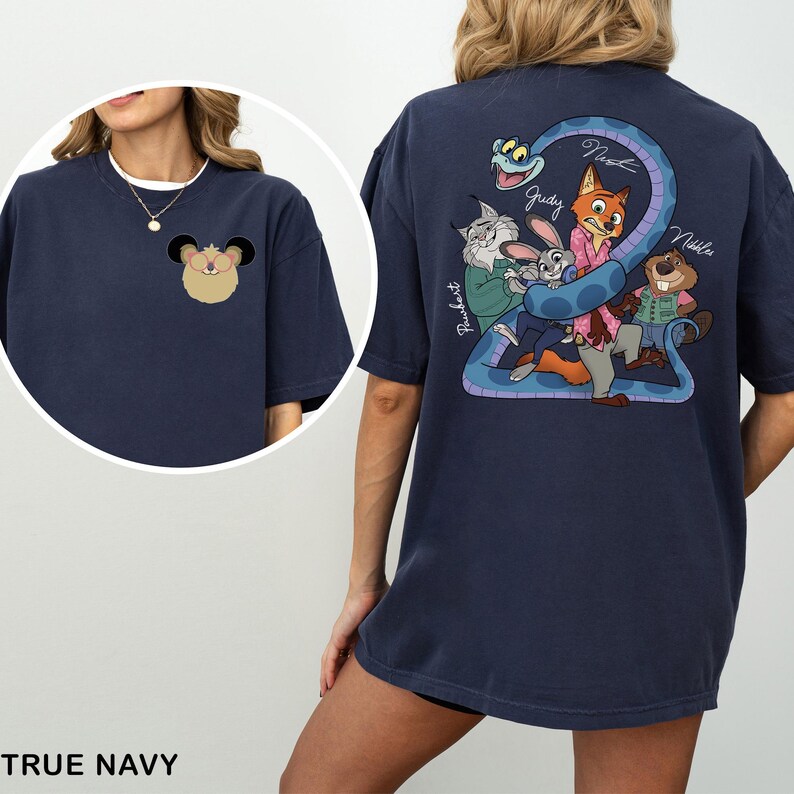 May include: True navy blue t-shirt featuring a cartoon illustration of a character on the front and a group of characters with a snake on the back. The back graphic includes the names Judy, Nick, and Nibbles.
