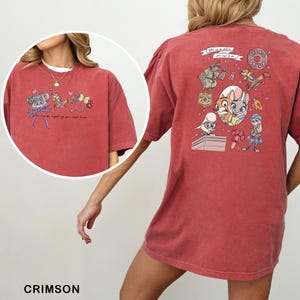 May include: Crimson t-shirt with cartoon graphics and text. The front has a circular graphic with a character and text. The back features multiple cartoon characters and the words "The Big Donut".