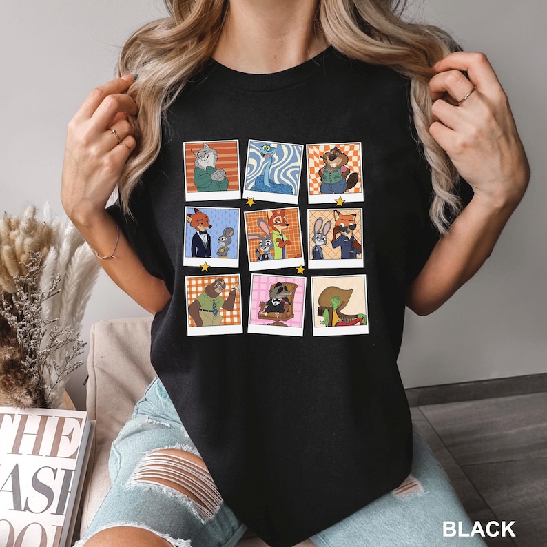 May include: Black t-shirt featuring a grid of nine cartoon character portraits in polaroid-style frames. Each frame showcases a different animal character in various outfits and poses. The word "BLACK" is printed at the bottom right.