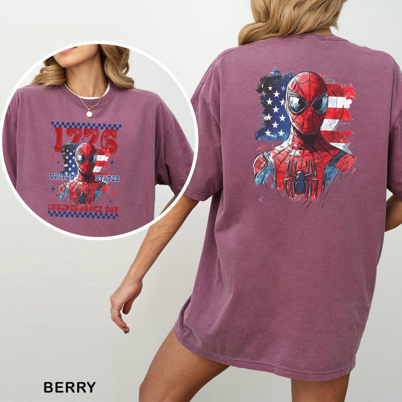 May include: A berry-colored t-shirt featuring a graphic of Spider-Man against a distressed American flag background. The back displays a large print of the character, while the front includes a smaller version with the text 1776 UNITED STATES INDEPENDENCE DAY.
