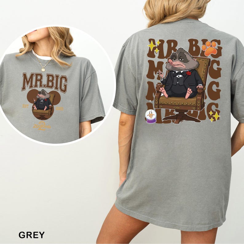 May include: Grey t-shirt with a cartoon illustration of a character in a suit seated in a chair. The front of the shirt displays the text "MR. BIG" above the character. The back of the shirt repeats the text and image.