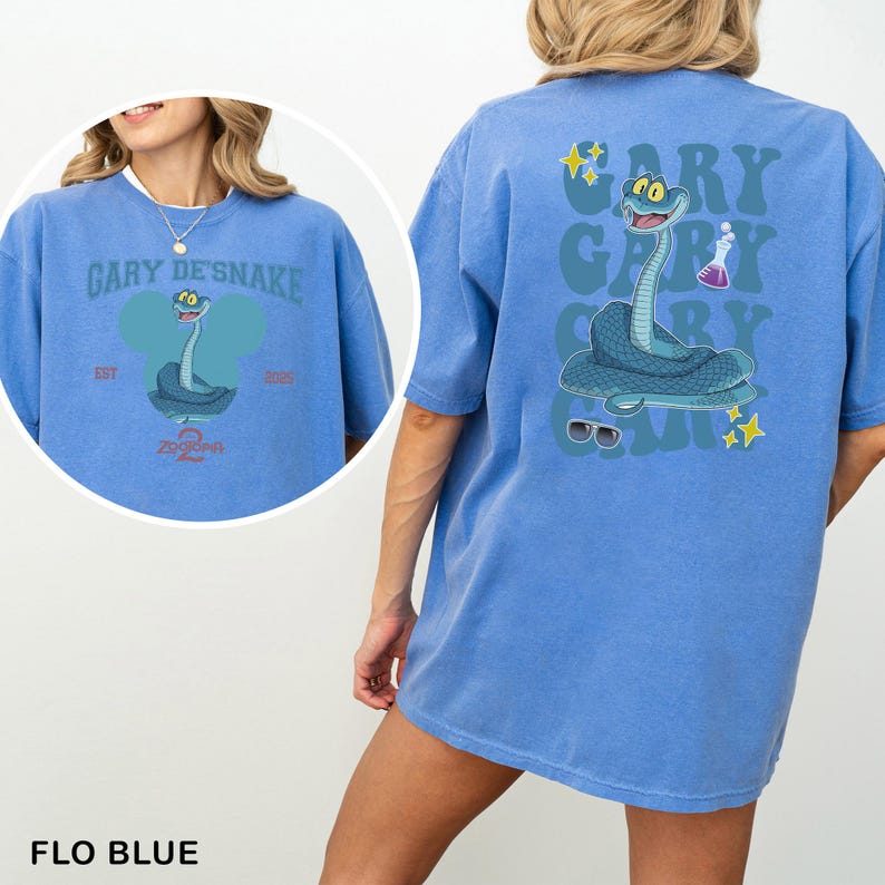 May include: Flo blue t-shirt with a cartoon snake design and the text "Gary De'Snake" and "Zooopa". The back of the shirt has a larger snake graphic with sunglasses, stars, and a beaker. The t-shirt has a relaxed fit.