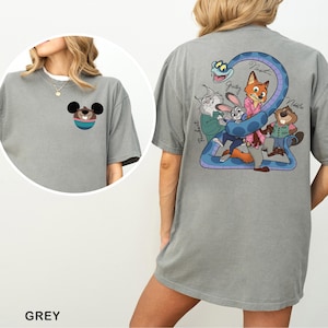 May include: Grey t-shirt featuring a cartoon design on the front and back. The front has a cartoon character's face. The back has a blue snake with cartoon characters. The word "GREY" is at the bottom of the shirt.