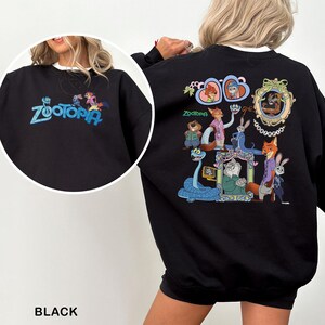 Puede incluir: Sudadera negra con la palabra "Zootopia" en azul en la parte delantera. La parte trasera de la sudadera muestra personajes de dibujos animados coloridos de la pel&iacute;cula "Zootopia". La sudadera es de cuello redondo.
